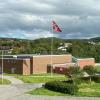 Gymbygget en overskyet sommerdag, flaggstang med norsk flagg