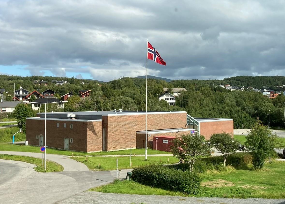 Gymbygget en overskyet sommerdag, flaggstang med norsk flagg - Klikk for stort bilde